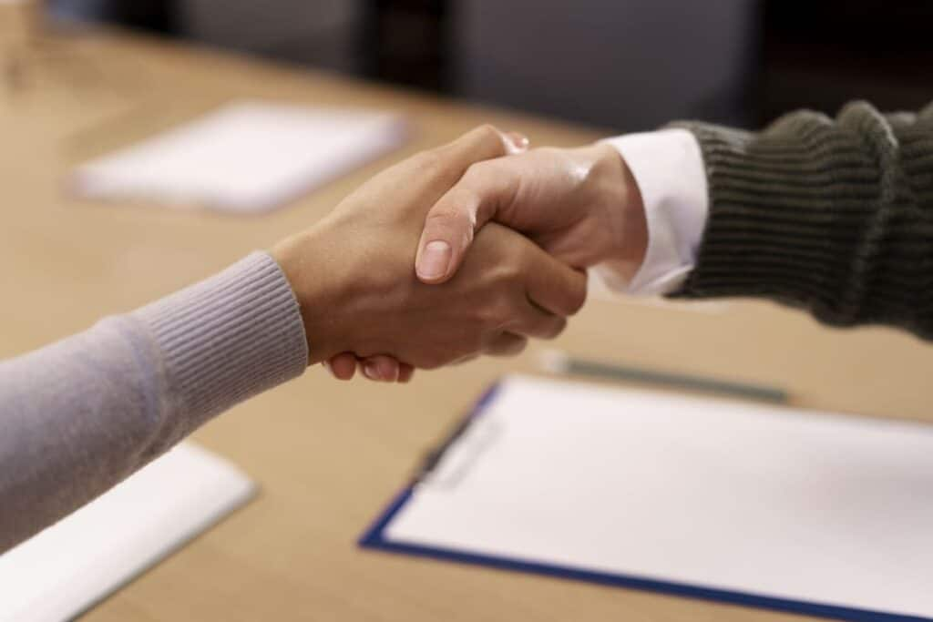 Einkommenspotenzial Earning potential reflected in a professional handshake over a signed document, symbolizing agreement, trust, and income growth through strategic career decisions