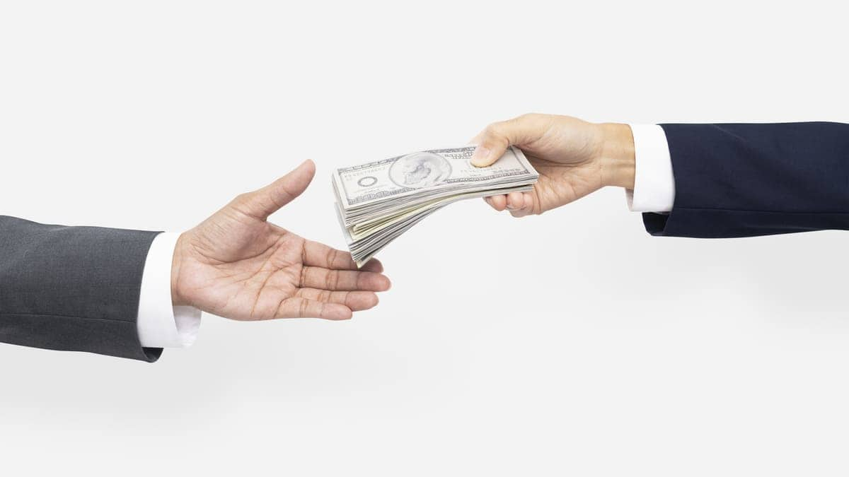 Gehalt salary negotiation moment showing one person handing cash to another during a professional agreement