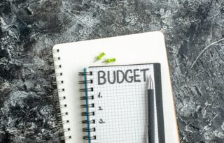 A small, grid-lined notepad with the word 