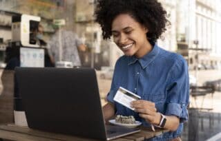 credit beginner using a laptop and credit card at home while learning how to manage personal finances in the U.S.