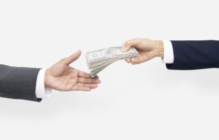 salary negotiation moment showing one person handing cash to another during a professional agreement