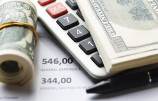 Smart cash flow strategies illustrated by U.S. dollar bills, a calculator, and a personal expense sheet showing income, expenses, and savings planning.