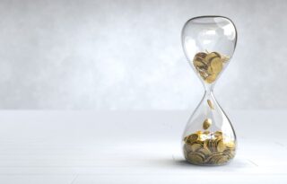 Wealth symbolized by an hourglass filled with golden coins, representing time, money, and long-term financial growth